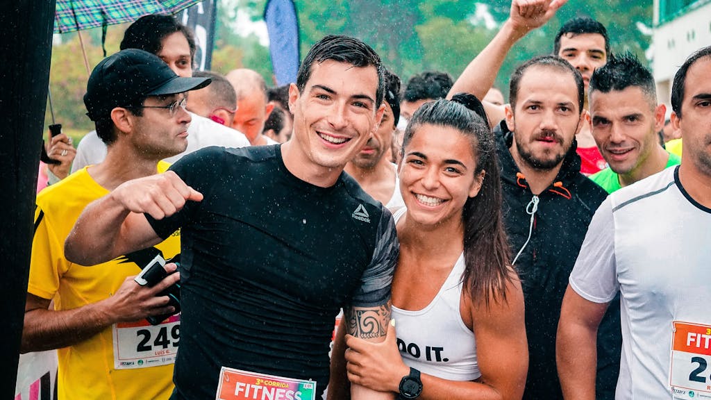 Group of runners smiling in the rain during a marathon race event.