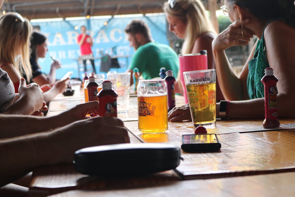 People enjoying drinks at an outdoor event with live music on a sunny day.